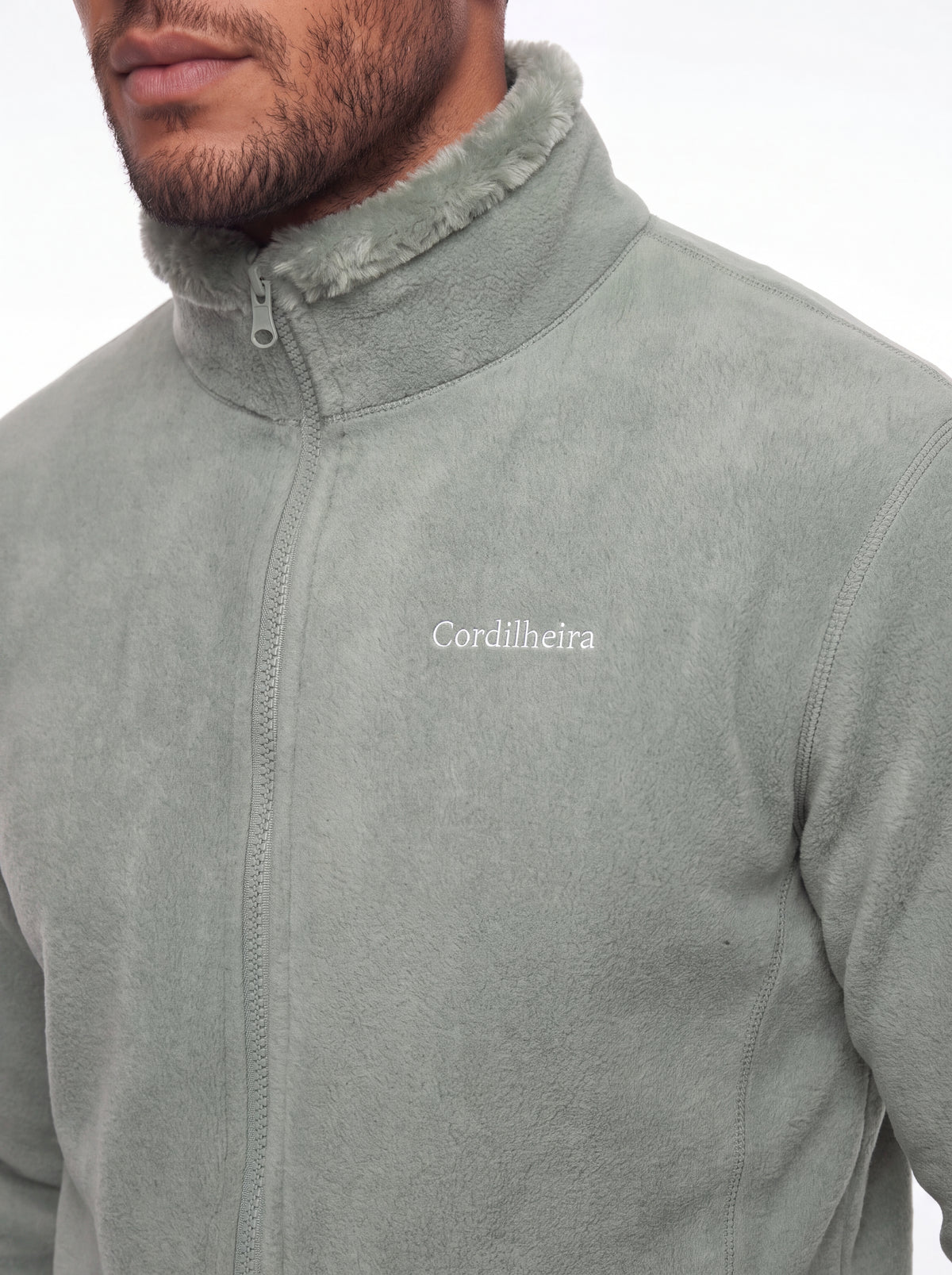Modelo inclinado mostrando detalhes em 4K do Fleece Cordilheira Coats da Marca Cordilheira, Roupa de Boa resistência e acabamento Confiável.
