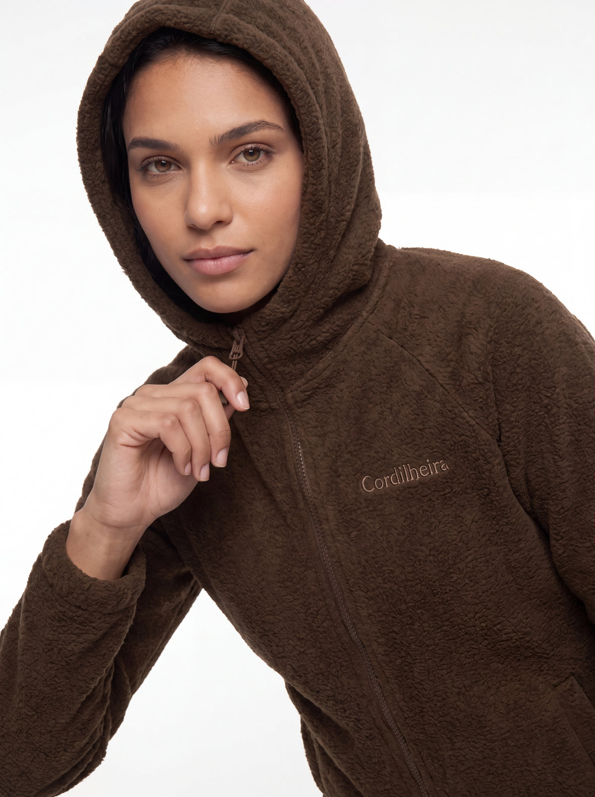 Modelo ajustando o capuz e a gola da Jaqueta Cordilheira Fleece Hooded Feminina, Roupa da Marca Cordilheira com Boa qualidade, conforto e funcionalidade Confiável para uso outdoor.