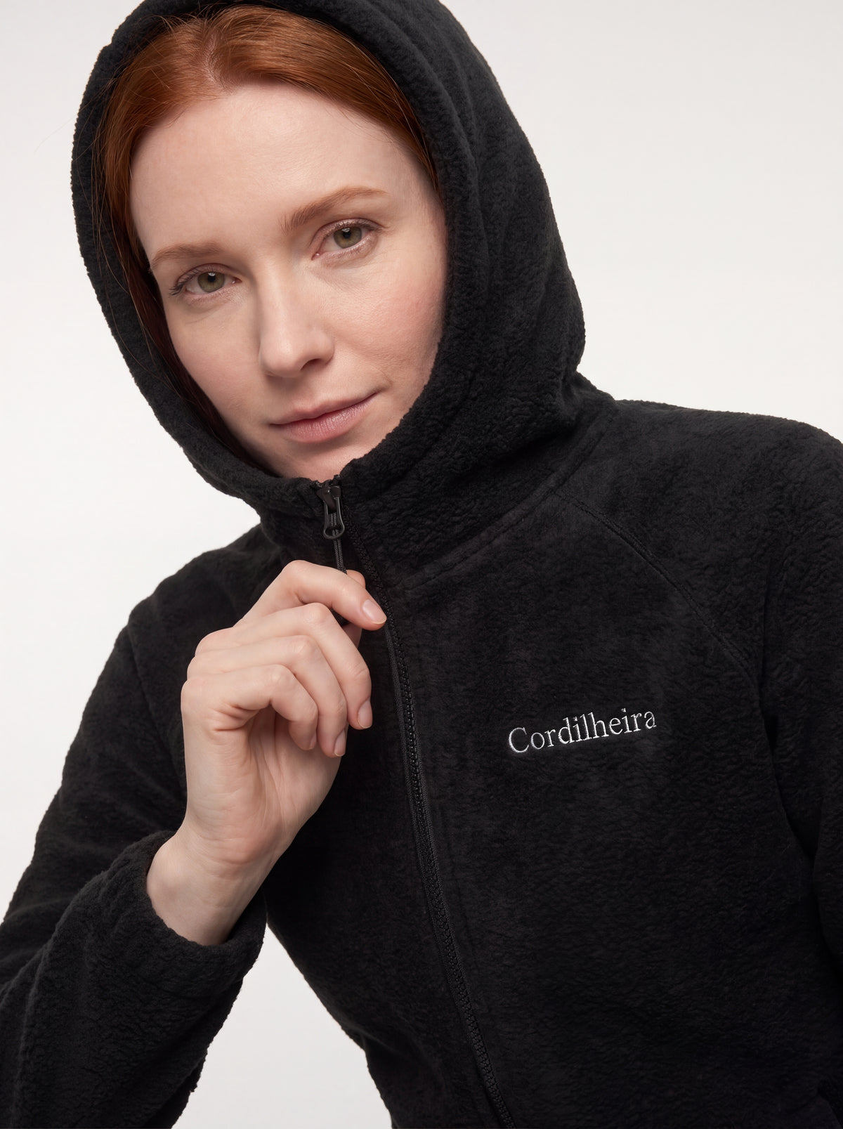 Modelo usando Jaqueta Cordilheira Fleece Hooded Feminina com capuz, Roupa da Marca Cordilheira com Boa qualidade, conforto e resistência Confiável para trilhas, trekking e frio.