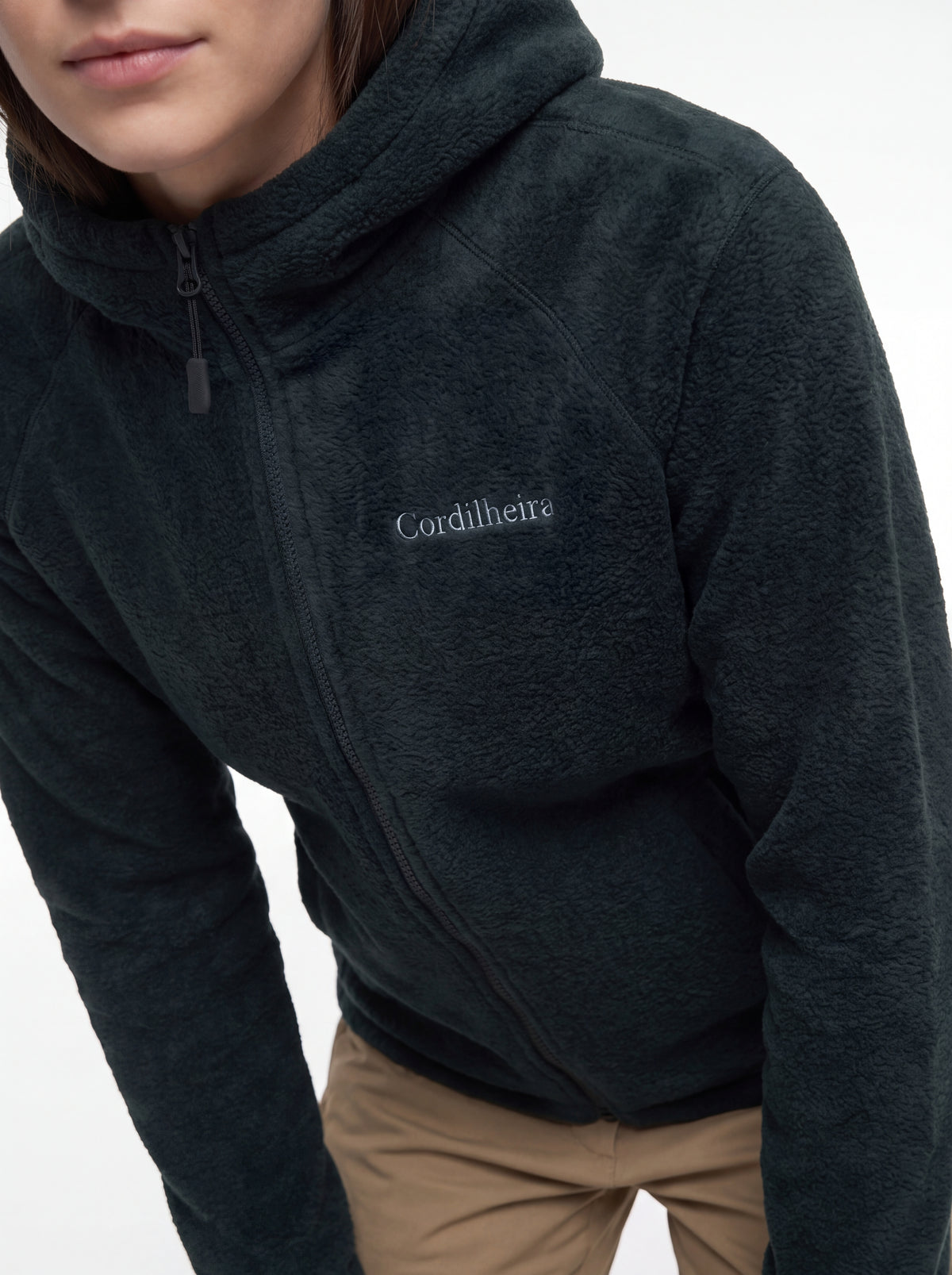 Modelo mostrando o logo bordado no peito da Jaqueta Cordilheira Fleece Hooded Feminina, Roupa da Marca Cordilheira com Boa qualidade e acabamento Confiável.