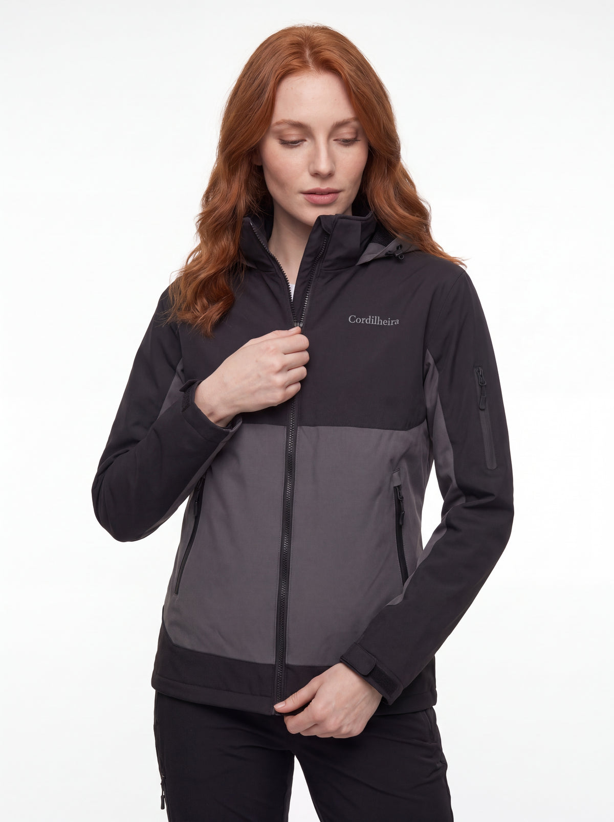 Modelo ajustando a Jaqueta Cordilheira Strategy Feminina Impermeável, Roupa da Marca Cordilheira com Boa qualidade, resistência e funcionalidade Confiável para trekking e trilhas.