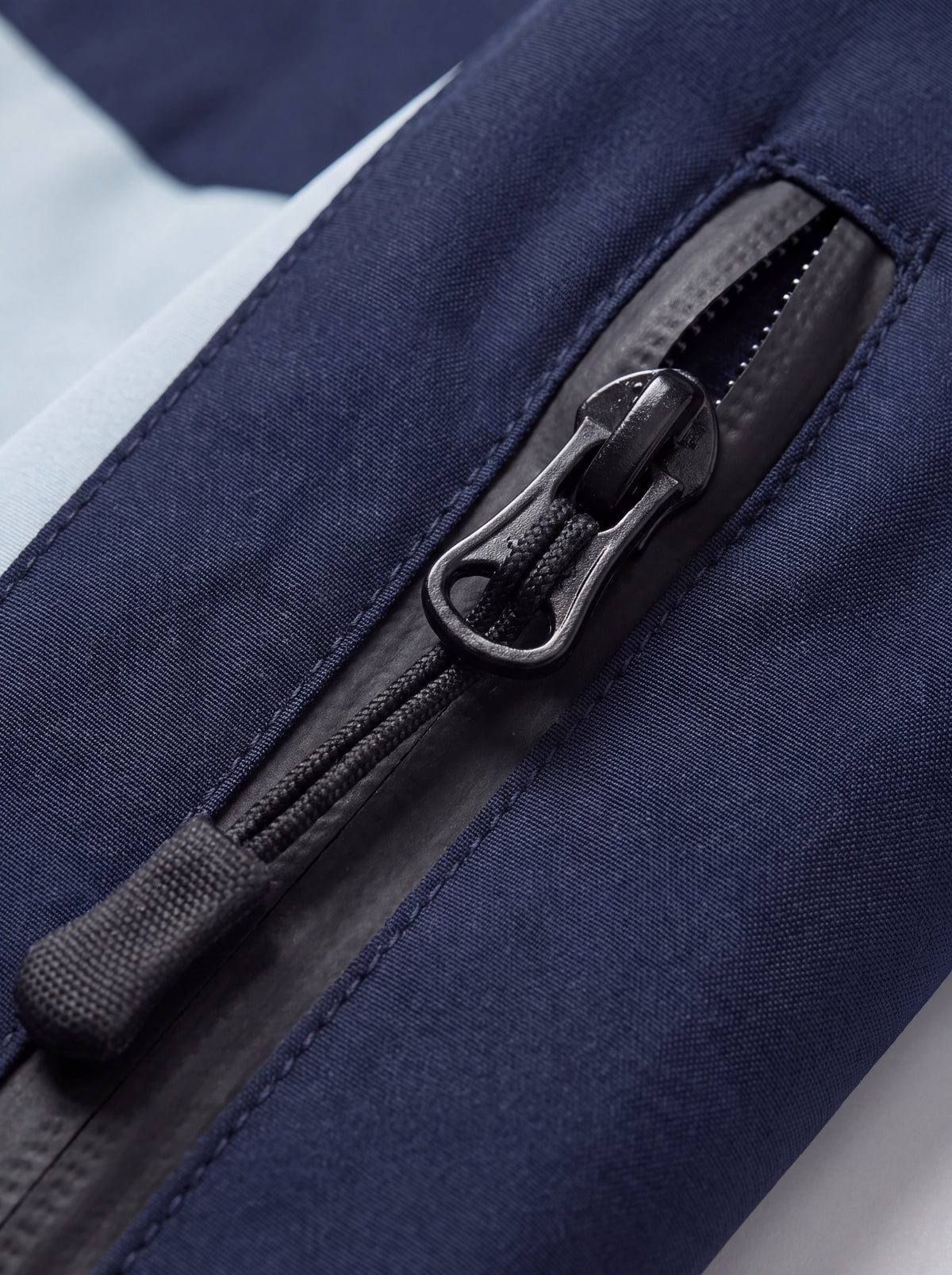 Close-up do zíper da Jaqueta Cordilheira Strategy Feminina Impermeável, Roupa da Marca Cordilheira com Boa qualidade, resistência e acabamento Confiável para trilhas e uso ao ar livre.