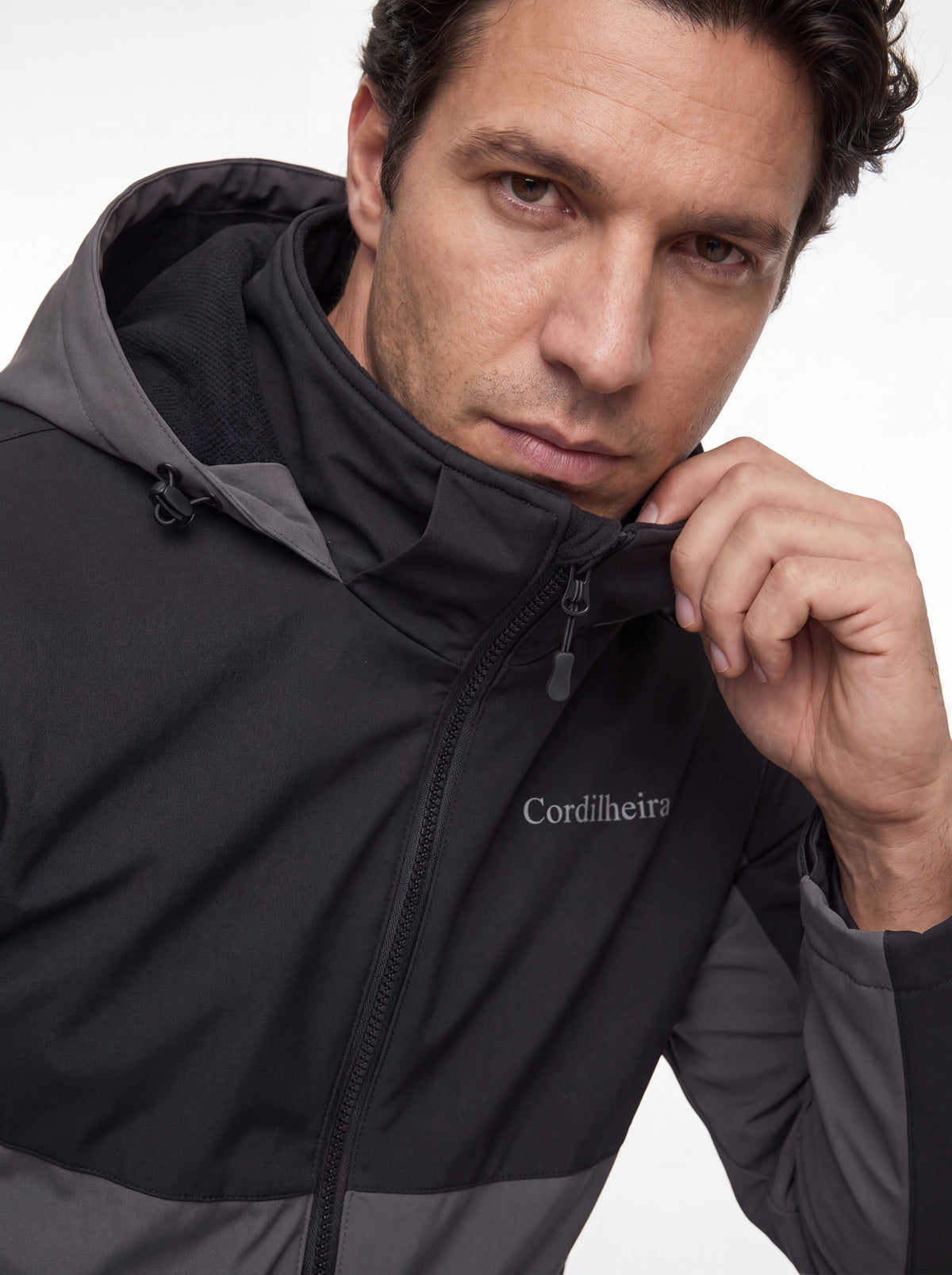 Modelo ajustando a gola da Jaqueta Cordilheira Strategy Masculina Impermeável, Roupa da Marca Cordilheira com Boa proteção, resistência e conforto Confiável contra vento e mudanças do clima.