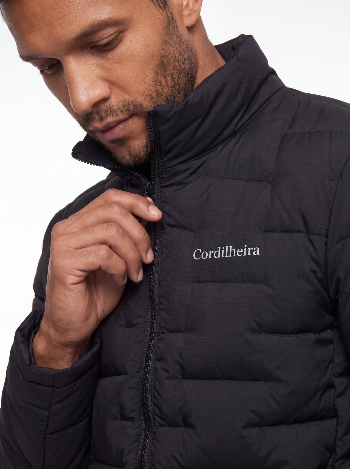 Modelo ajustando a gola da Jaqueta Puffer Cordilheira On The City Masculina, Roupa da Marca Cordilheira com Boa qualidade, conforto e proteção Confiável para dias frios.