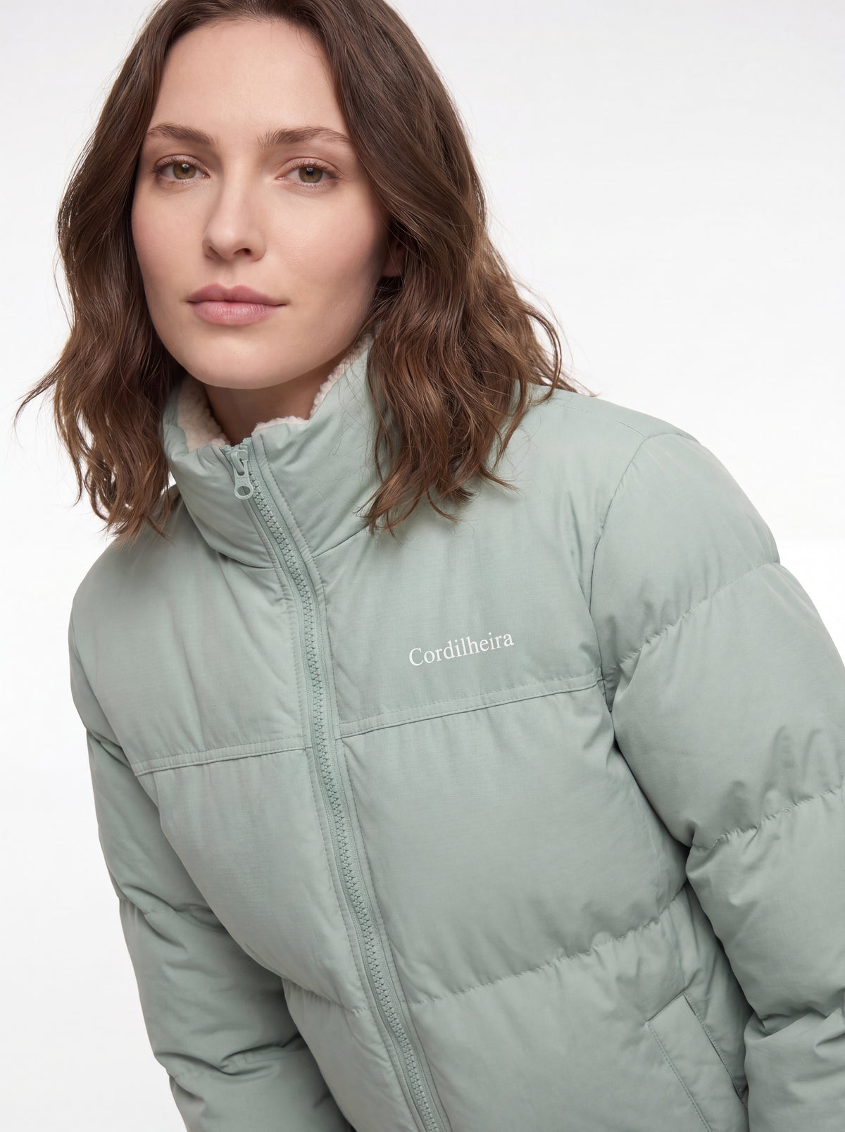Detalhe da logo e acabamento da Jaqueta Puffer FrostLayer Dupla Face Feminina, Roupa da Marca Cordilheira com Boa construção e visual Confiável.