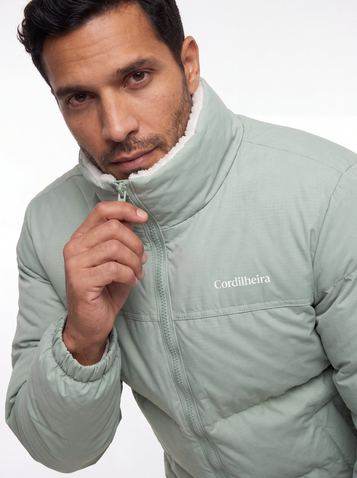 Modelo interagindo com a gola da Jaqueta Puffer FrostLayer Dupla Face Masculina, Roupa da Marca Cordilheira com Boa proteção Confiável para frio.