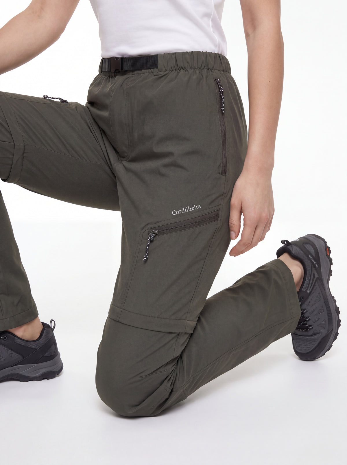 Modelo ajoelhada com calçado de trilha usando Calça 2 em 1 Cordilheira Canopy Feminina, Roupa da Marca Cordilheira com Boa mobilidade, resistência e conforto Confiável para atividades ao ar livre.