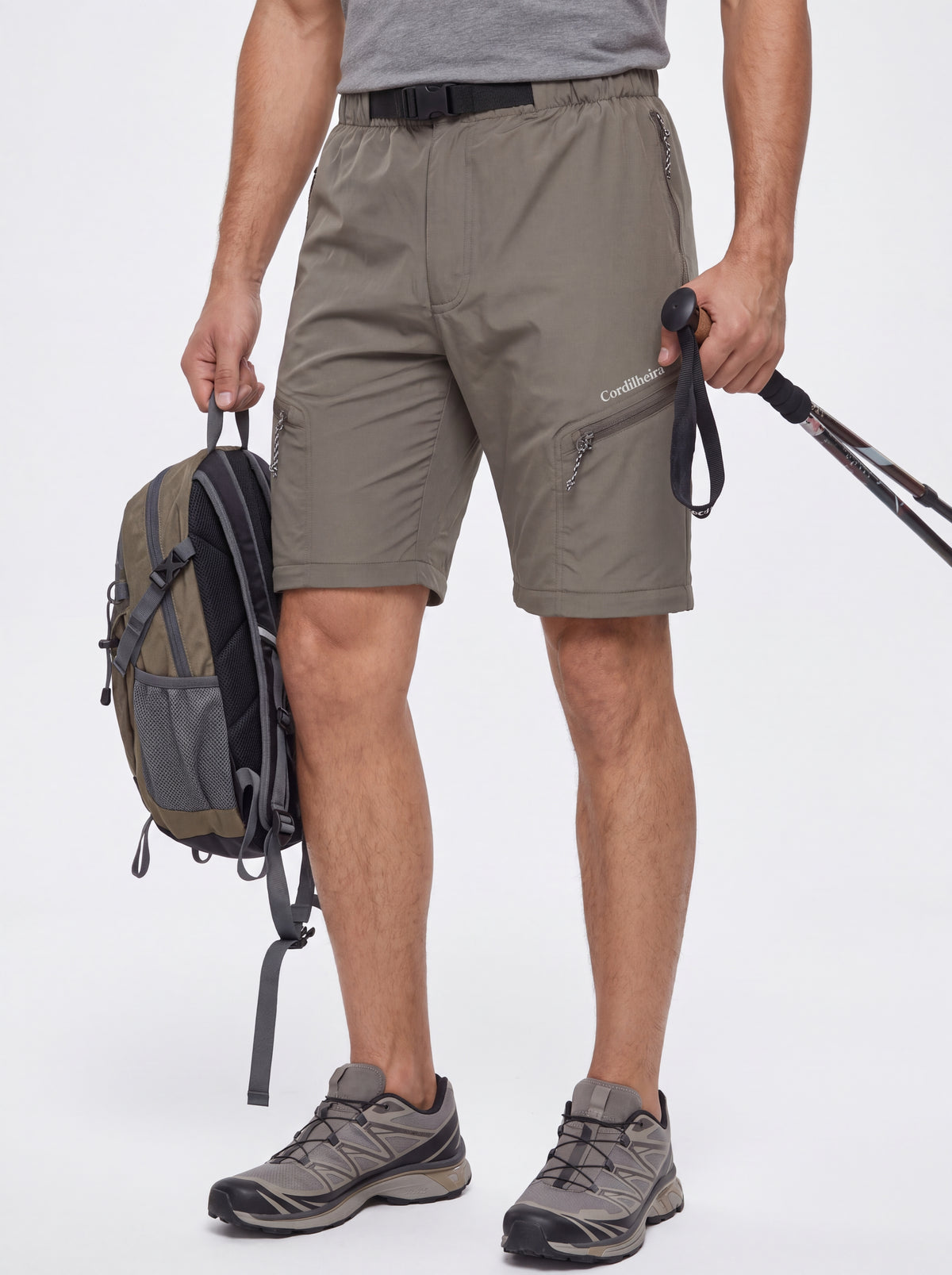 Modelo usando shorts da Calça 2 em 1 Cordilheira Canopy Masculina com equipamento outdoor, Roupa da Marca Cordilheira com Boa resistência, conforto e funcionalidade Confiável para aventuras.