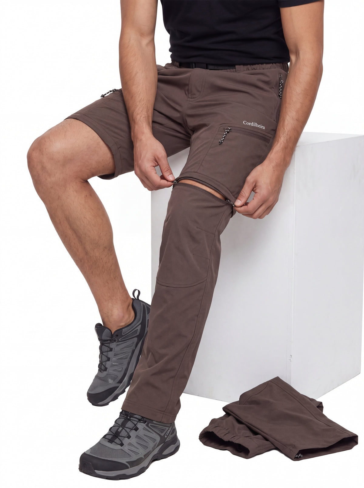 Modelo transformando a Calça 2 em 1 Cordilheira Canopy Masculina em shorts pelo sistema de zíper, Roupa da Marca Cordilheira com Boa versatilidade, resistência e funcionalidade Confiável para trilhas.