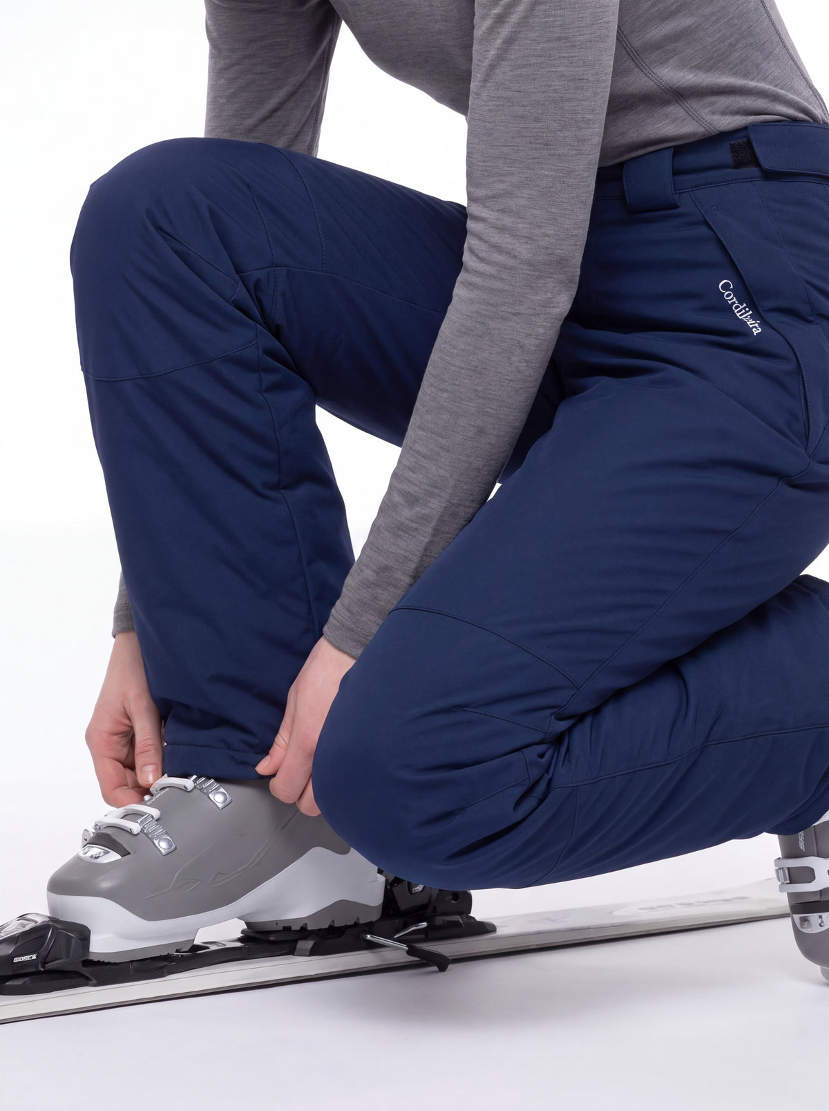 Modelo colocando esquis com Calça 2 em 1 Cordilheira Pathfinder Feminina, Roupa da Marca Cordilheira com Boa proteção e desempenho Confiável para ski e esportes na neve.