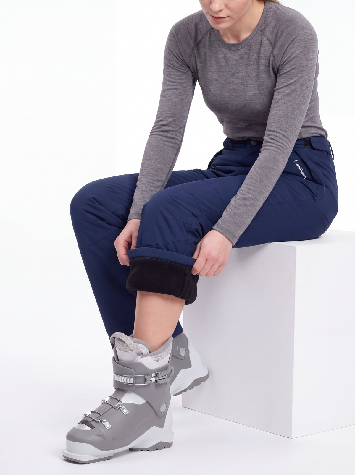 Modelo posando com botas e Calça 2 em 1 Cordilheira Pathfinder Feminina, Roupa da Marca Cordilheira com Boa qualidade e uso Confiável para neve e atividades outdoor.