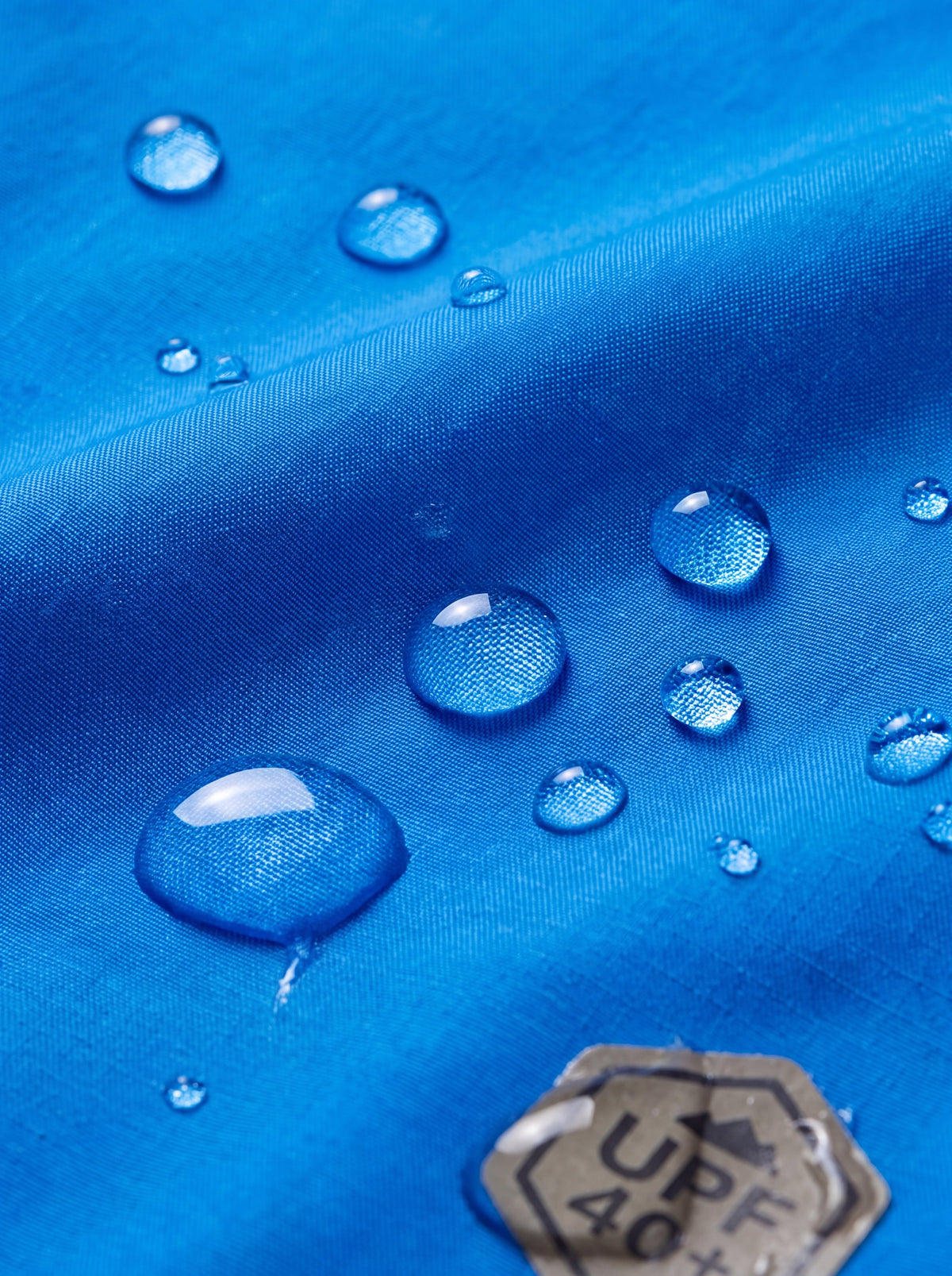Gotas de água no tecido do Corta-Vento Cordilheira Whisper Impermeável UV40+, Roupa da Marca Cordilheira com Boa resistência e proteção Confiável contra chuva.