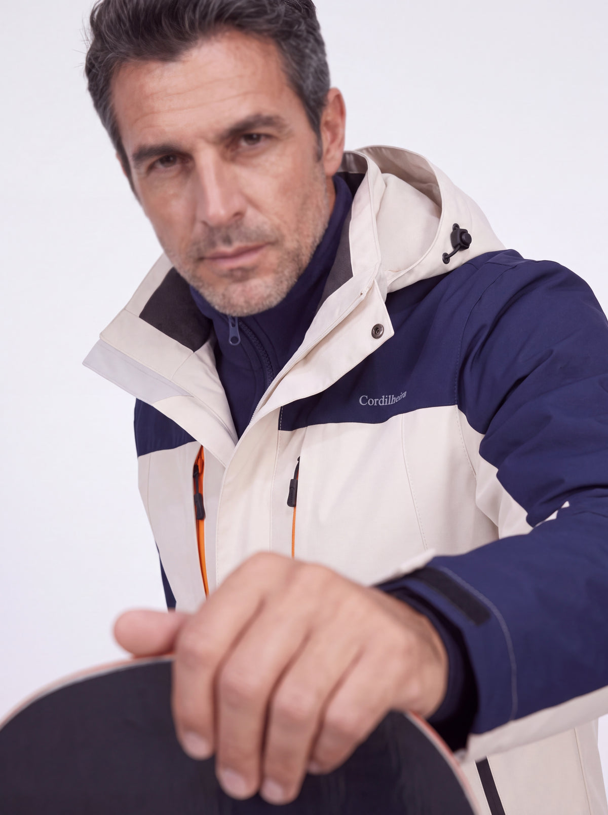 Pessoa segurando snowboard com Jaqueta 3 em 1 Cordilheira Thermal Shield, Roupa da Marca Cordilheira com Boa resistência e proteção Confiável.
