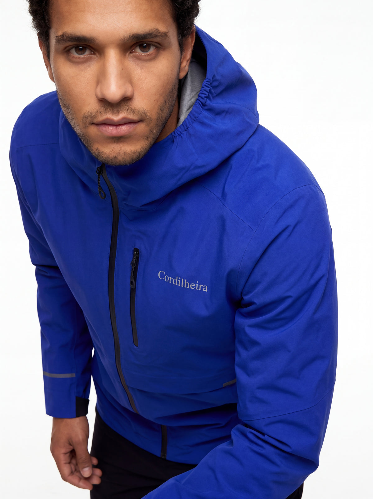 Modelo mostrando detalhes do logo da Jaqueta Anorak Cordilheira Defletor Masculina, Roupa da Marca Cordilheira com Boa qualidade, resistência e acabamento Confiável.
