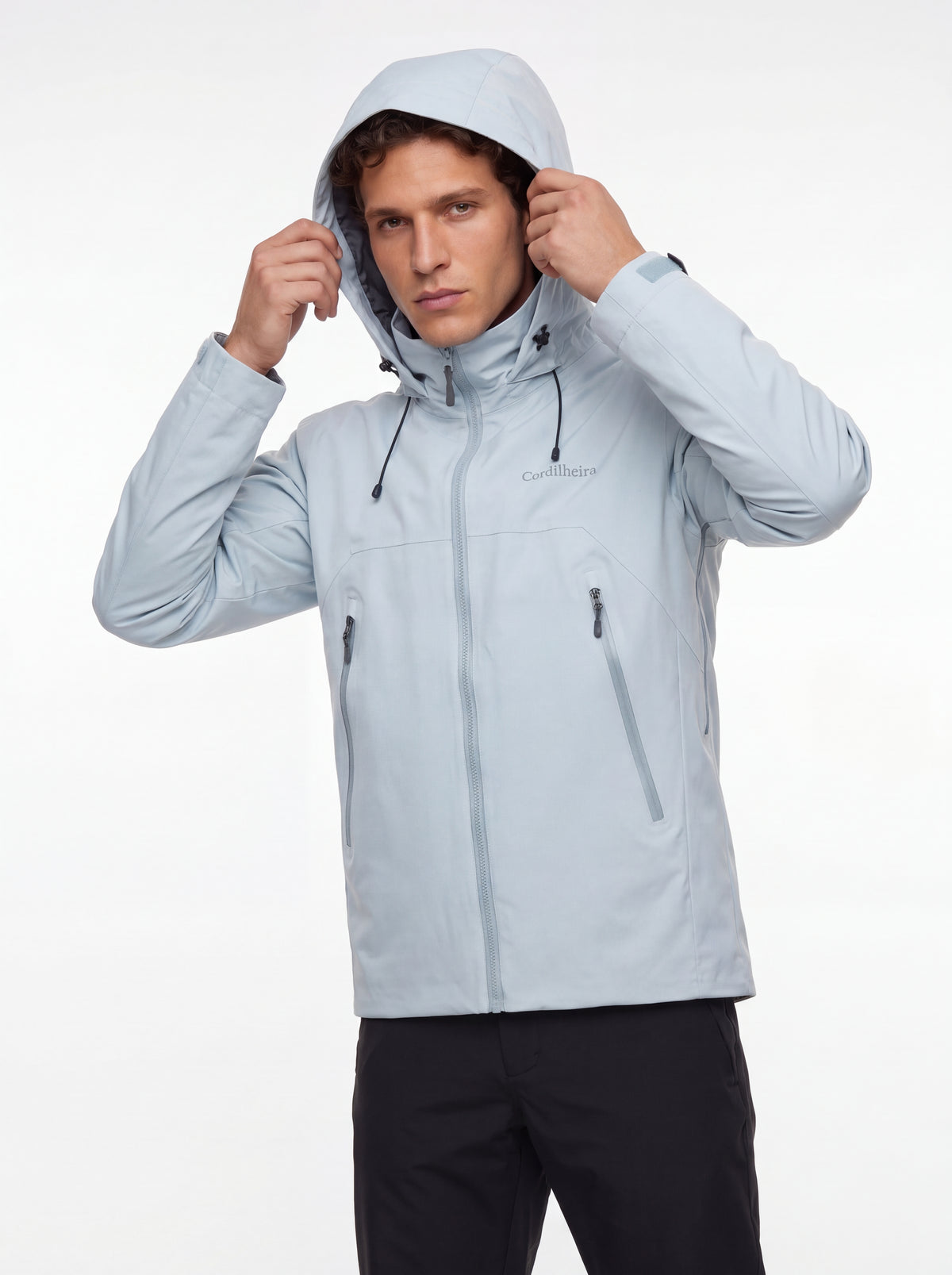 Modelo colocando o capuz da Jaqueta Anorak Cordilheira Heavy Storm Masculina, Roupa da Marca Cordilheira com Boa resistência e proteção Confiável para vento, frio e neve.