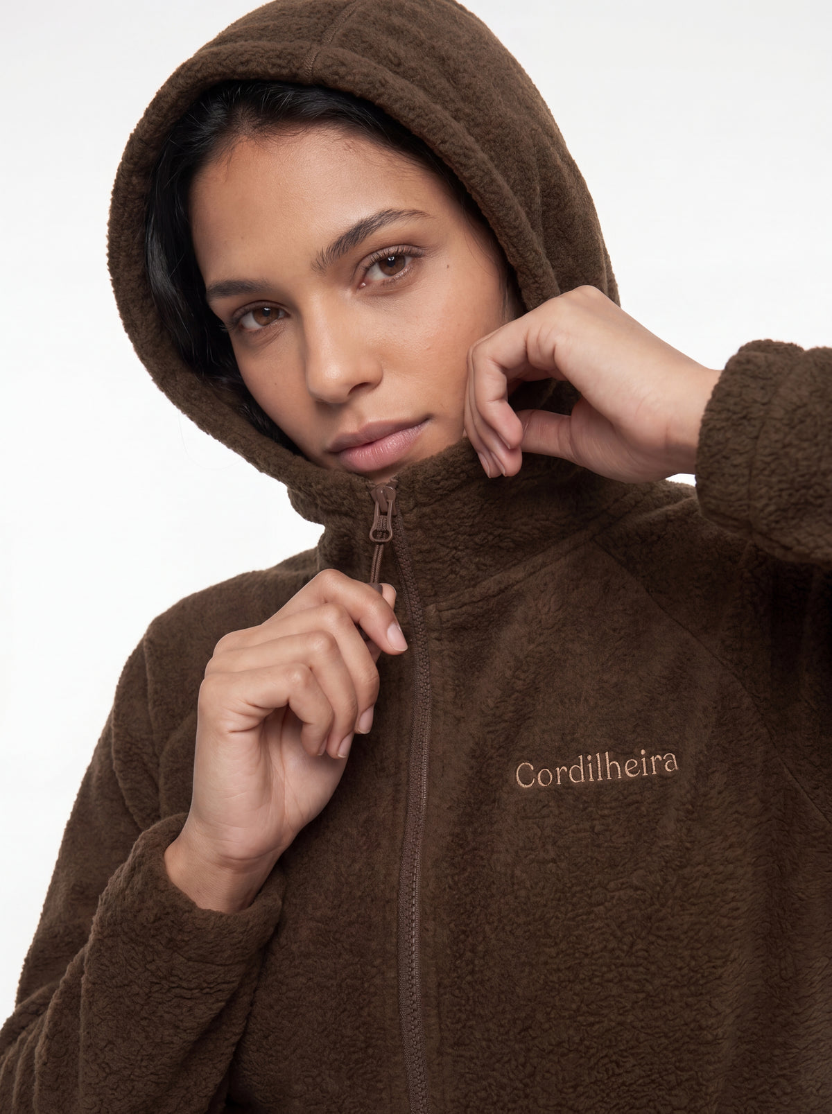 Modelo interagindo com a gola e o capuz da Jaqueta Cordilheira Fleece Hooded Feminina, Roupa da Marca Cordilheira com Boa qualidade, conforto e funcionalidade Confiável para frio.