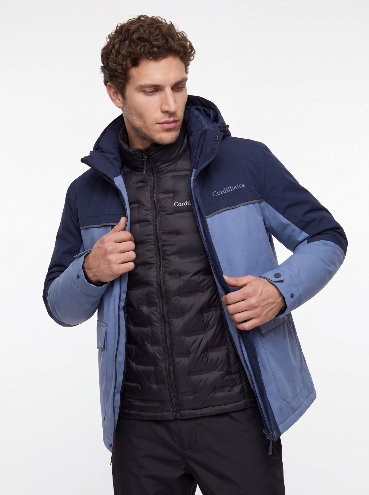Modelo abrindo o zíper da Jaqueta Puffer 3 em 1 Cordilheira Hybrid Masculina, Roupa da Marca Cordilheira com Boa qualidade e versatilidade Confiável para uso em diferentes camadas.