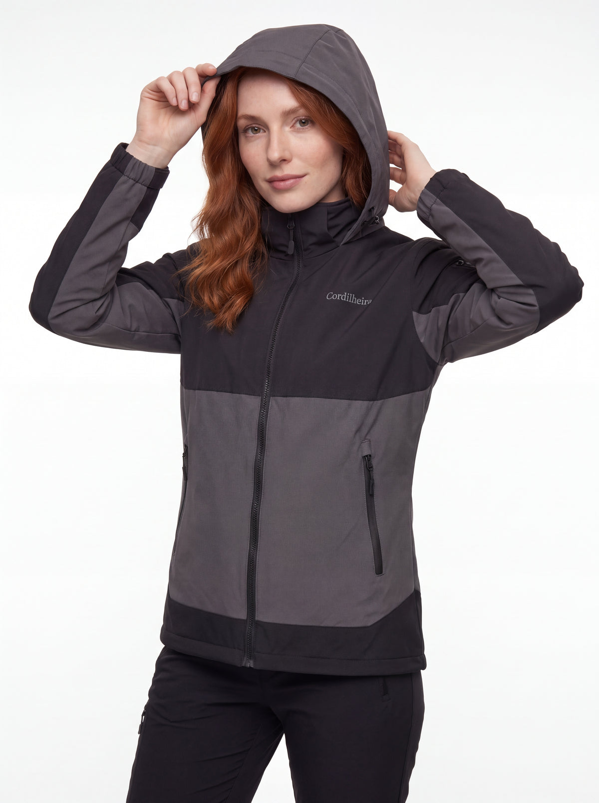 Modelo colocando o capuz da Jaqueta Cordilheira Strategy Feminina Impermeável, Roupa da Marca Cordilheira com Boa resistência e proteção Confiável para atividades ao ar livre.