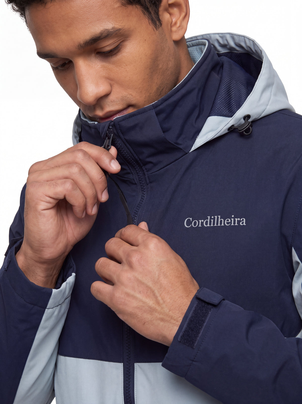 Modelo ajustando a gola da Jaqueta Cordilheira Strategy Masculina Impermeável, Roupa da Marca Cordilheira com Boa resistência e proteção Confiável para vento, frio e atividades outdoor.