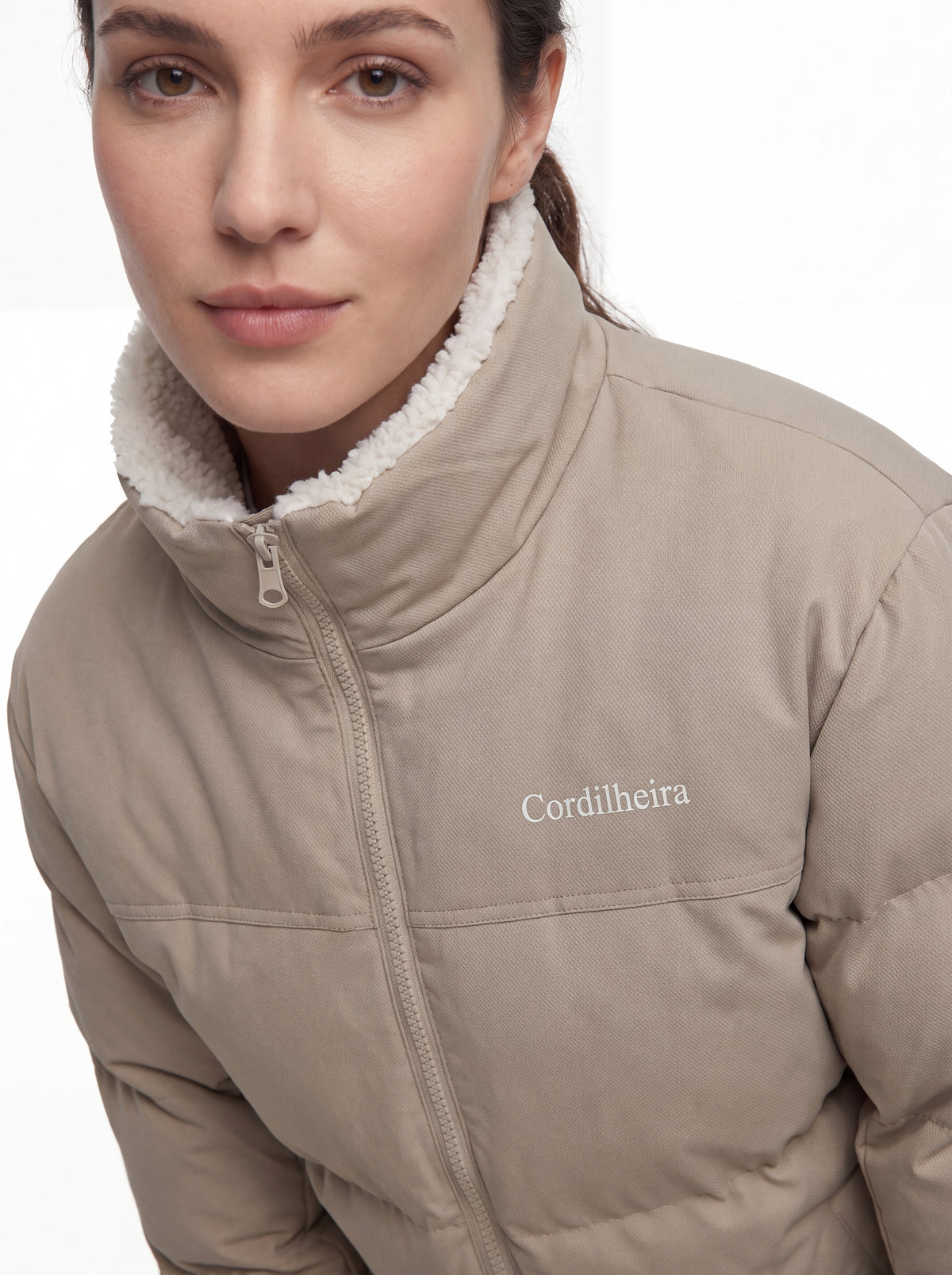 Close-up da gola e logo da Jaqueta Puffer FrostLayer Dupla Face Feminina, Roupa da Marca Cordilheira com Boa qualidade e acabamento Confiável para frio.
