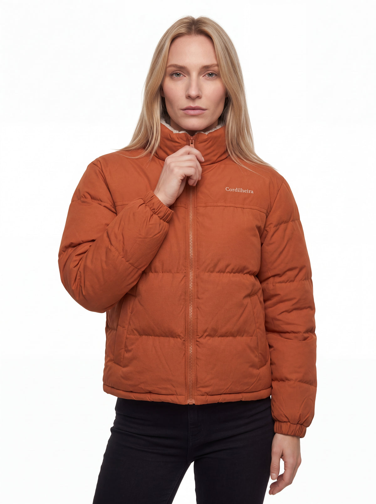 Jaqueta Puffer FrostLayer Dupla Face Feminina fechada em pose séria, Roupa da Marca Cordilheira com Boa proteção e estrutura Confiável para frio.