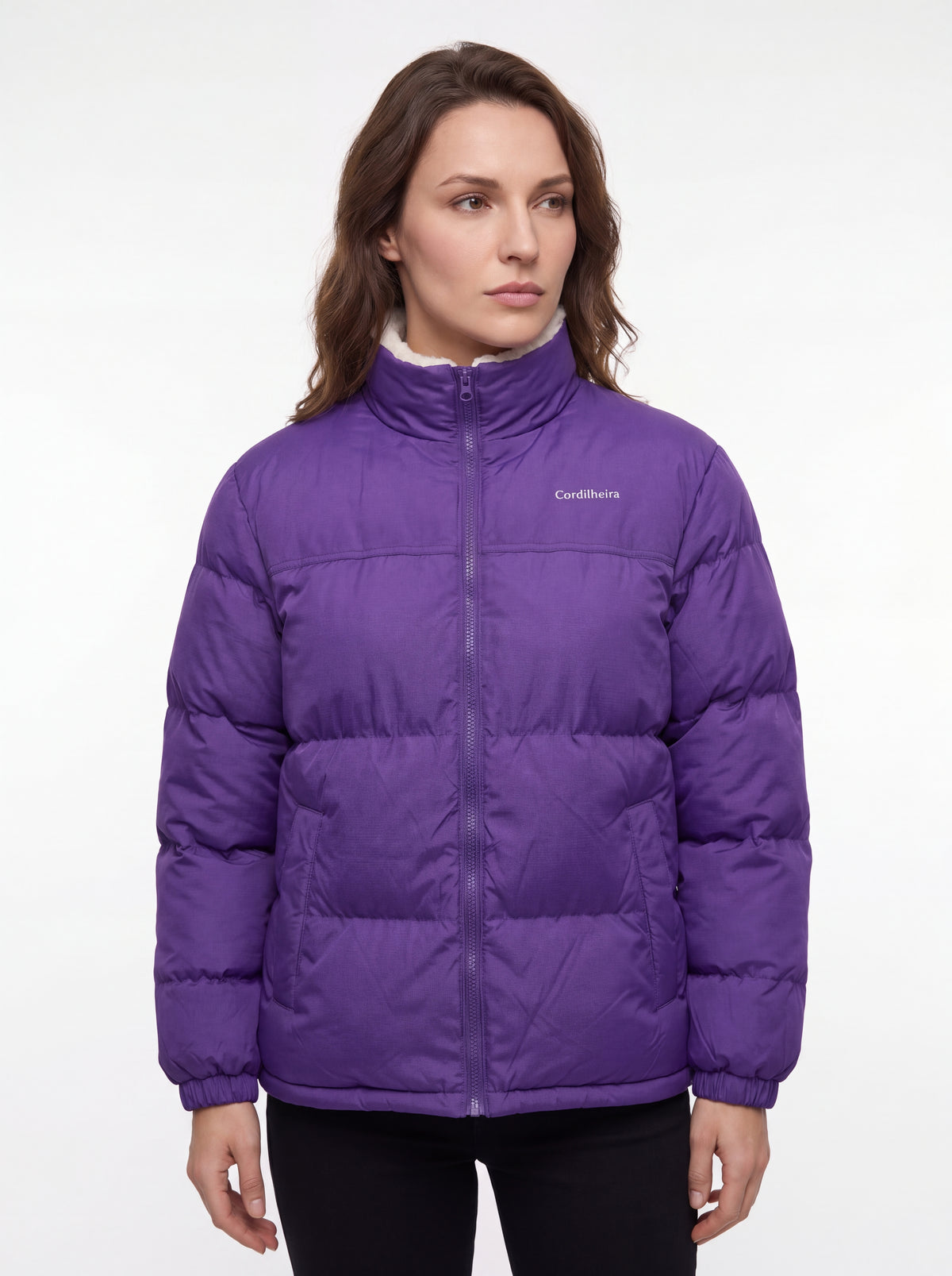 Mulher usando Jaqueta Puffer FrostLayer Dupla Face Feminina em pose séria, Roupa da Marca Cordilheira com Boa qualidade e uso Confiável para inverno.