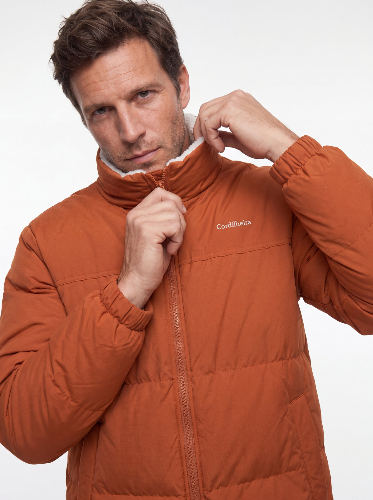 Modelo interagindo com a gola da Jaqueta Puffer FrostLayer Dupla Face Masculina em 4K, Roupa da Marca Cordilheira com Boa proteção Confiável para frio.