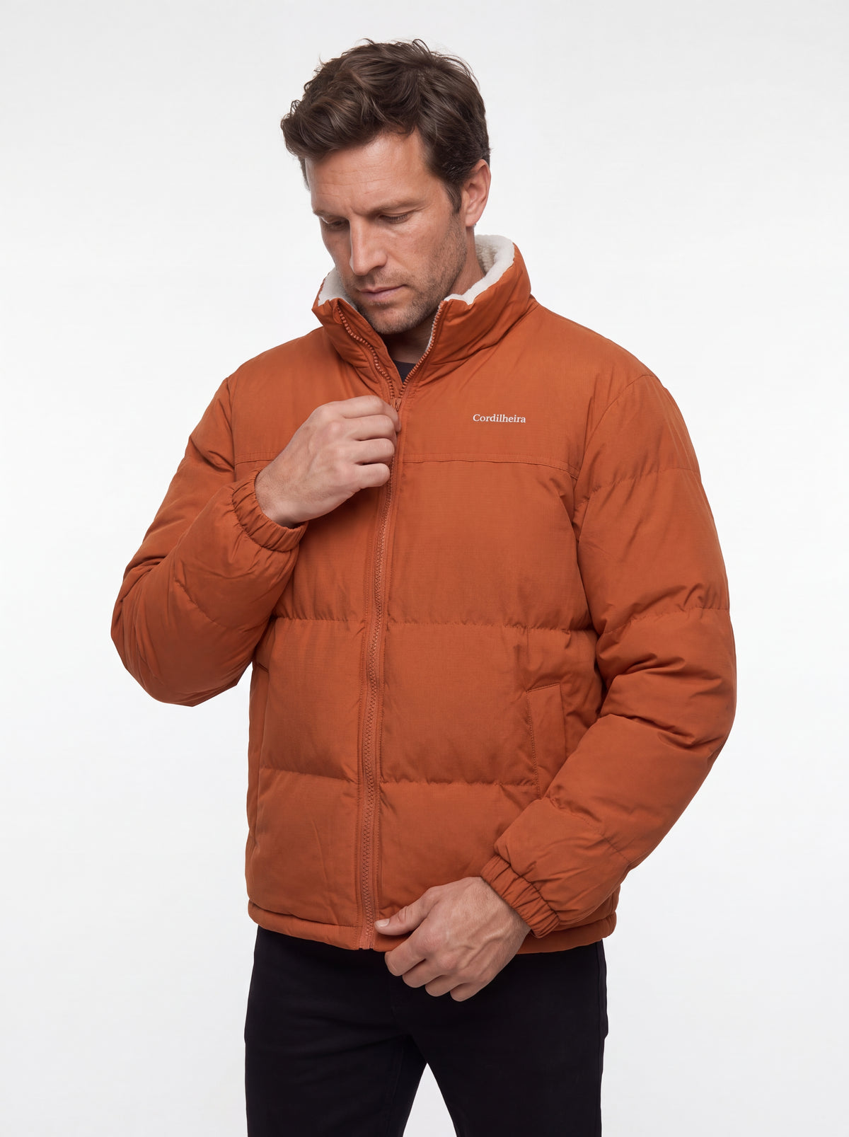 Modelo posando com Jaqueta Puffer FrostLayer Dupla Face Masculina, Roupa da Marca Cordilheira com Boa proteção e conforto Confiável para inverno.