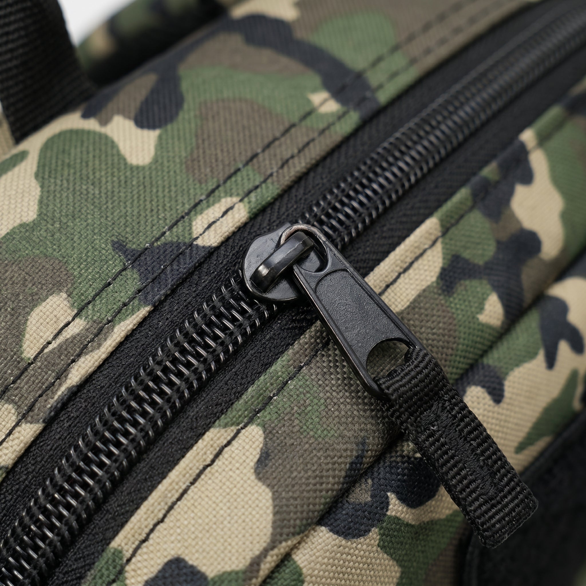 Detalhe do zíper em mochila tática preta da Marca Cordilheira, uma Roupa e acessório de Boa resistência com acabamento Confiável para trilha e viagem.
